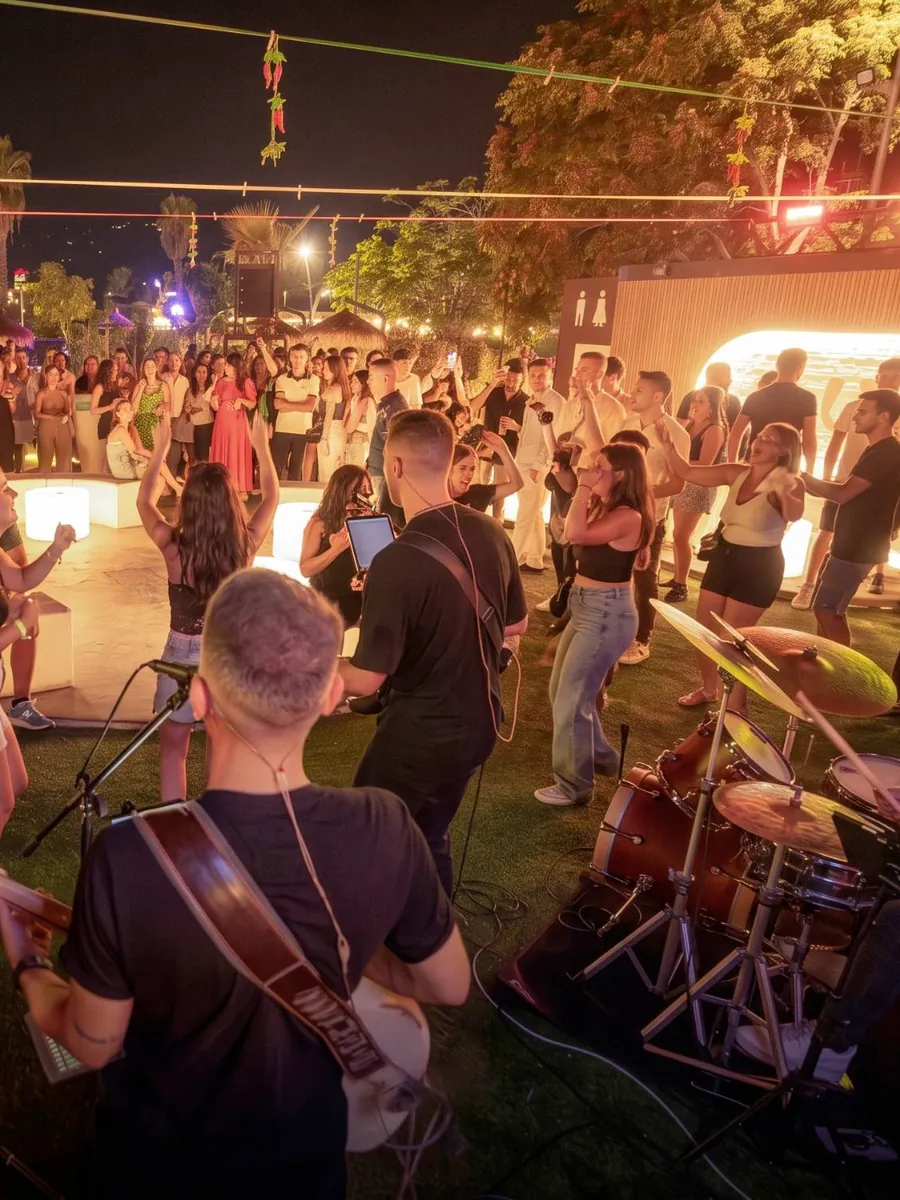 Band dal vivo all'aperto con il pubblico che balla